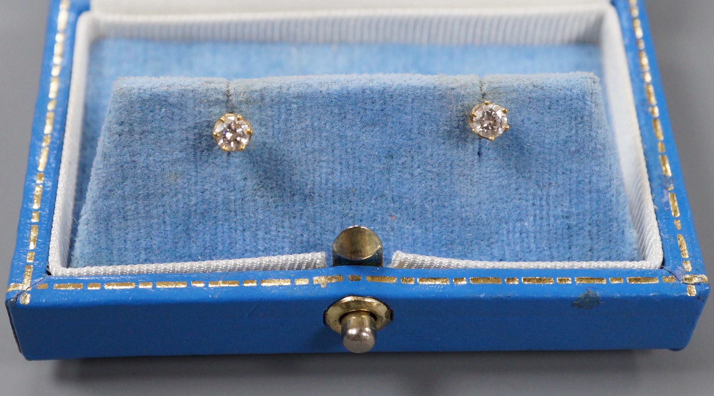 A pair of 750 yellow metal and solitaire diamond set ear studs, gross weight 0.9 grams